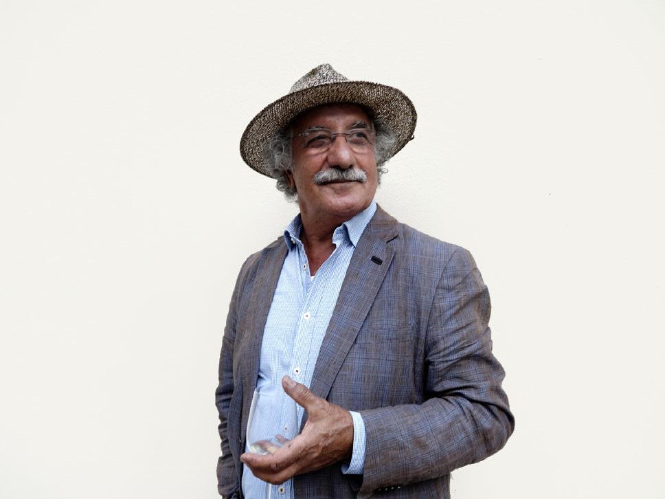 Porträt des Künstlers Akbar Behkalam, bekannt für seine ausdrucksstarken, abstrakten Kunstwerke, aufgenommen in einer entspannten Atmosphäre.