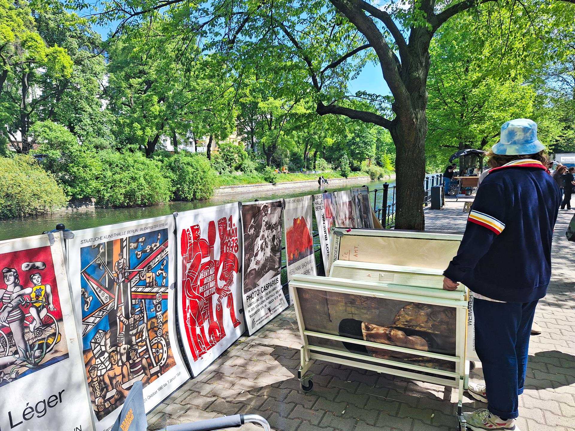 Man steht vor Plakatständer und einer Reihe mit Plakaten von Plakativo